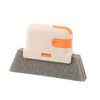 Cepillo universal para limpiar ventanas y rieles blanco y naranja sobre una superficie de fieltro gris.