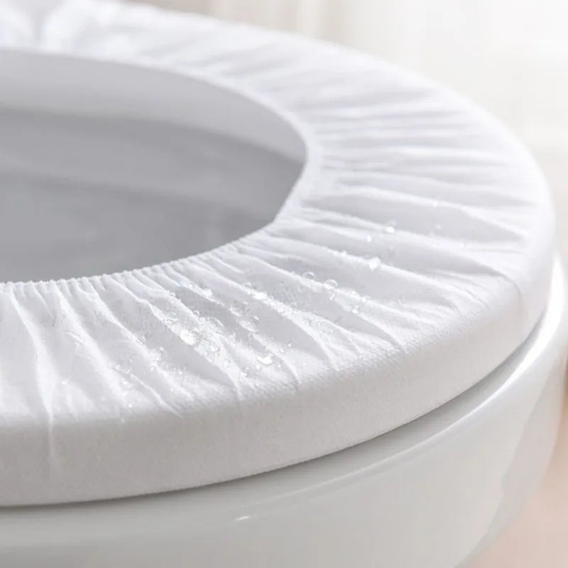 A close-up view of a white disposable toilet seat with ridges, showing some white powder on the surface.