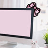 Figurine de chat blanc à côté d'un moniteur affichant un fond et un nœud rose.
