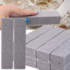 A hand is holding a gray reusable cleaning pumice stone stick, showing its texture and shape.