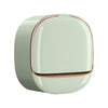 A round, light green wall-mounted soap dish with a lid and drainage feature.
