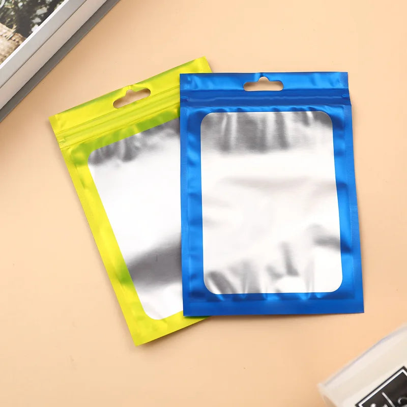 A set of two plastic pouches, one yellow and one blue, with silver foil inserts, displayed on a light background.