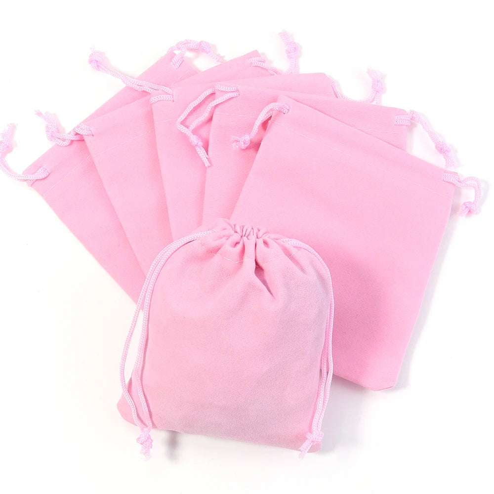 A stack of pink velvet drawstring jewelry bags.