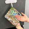 A hand is wiping a Totoro cartoon hanging towel on a dark surface.