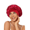 A woman wearing a vibrant red satin hair bonnet.