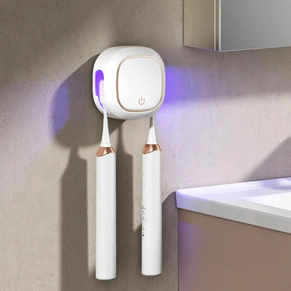 A white portable UV electric toothbrush cleaner with two brush heads hanging on a wall.