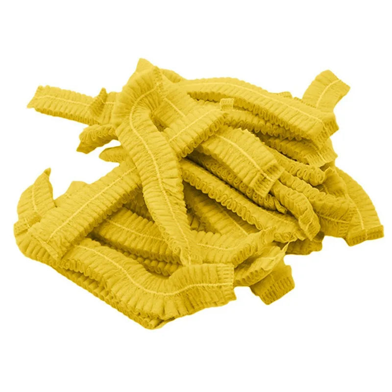 A pile of yellow disposable microblading hair net caps for permanent makeup.