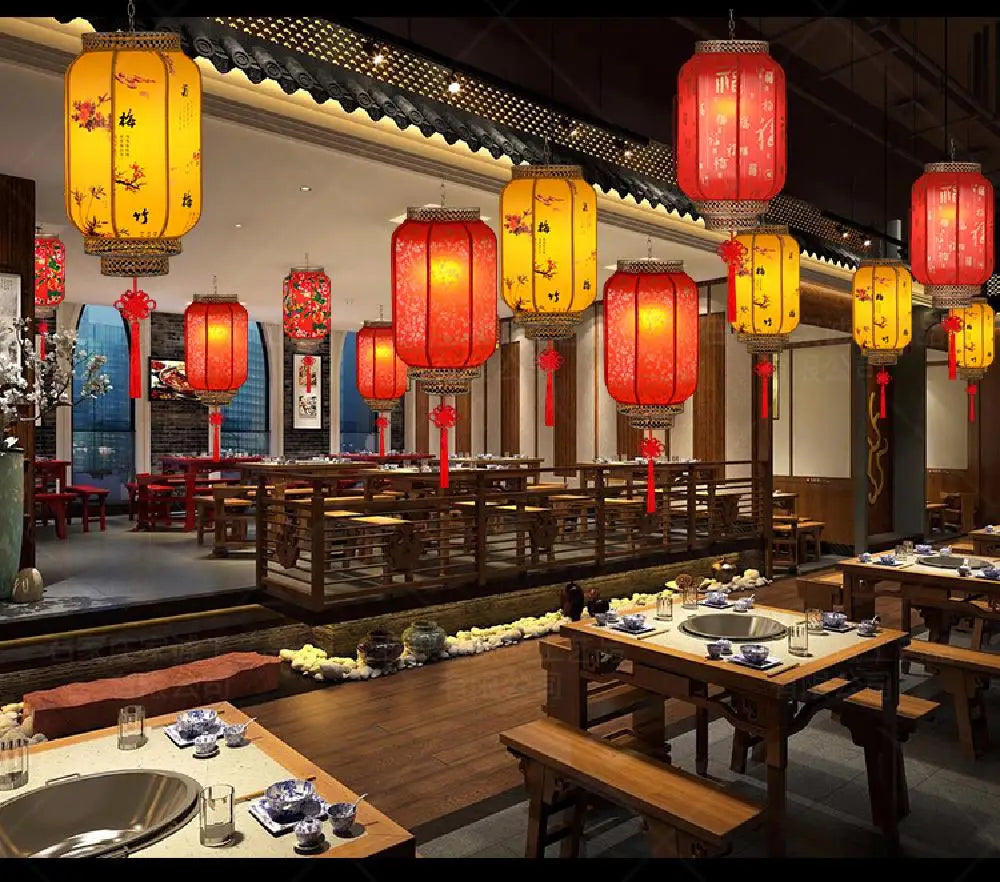 A row of large, vibrant red and yellow Chinese lanterns hang in a dimly lit interior setting.