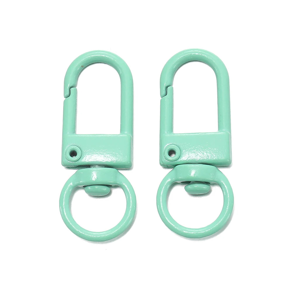 A pair of light mint green alloy snap lobster clasp hooks for jewelry making.