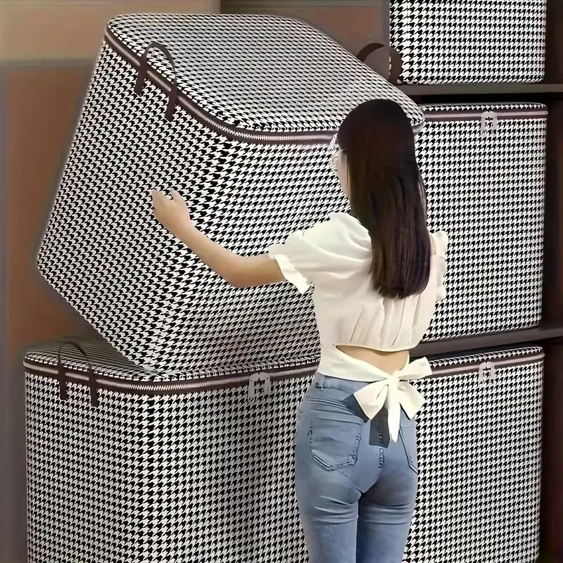 A woman in a white top and jeans is interacting with a stack of black and white checkered storage boxes.