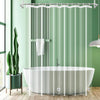 A modern bathtub setup featuring a glass shower curtain liner and a hanging shower rod in a light green bathroom.