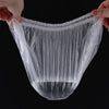 A hand is holding a clear, reusable disposable shower cap for hair protection, showing the mesh texture.