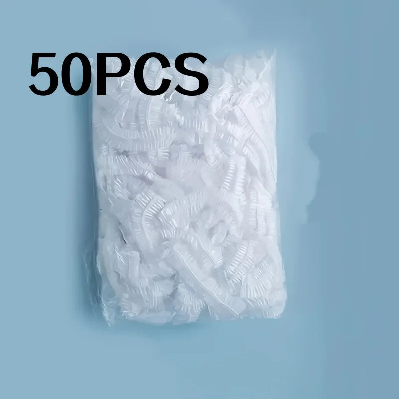 A pile of 50 disposable transparent shower caps is shown against a light blue background.