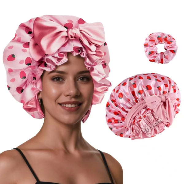 Pink satin silk hair bonnet with a strawberry print shown on a model and separate accessories