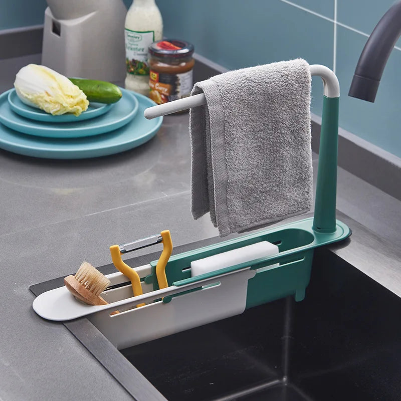 Un porte-ustensiles bleu sarcelle tient un torchon de cuisine et une brosse en bois dans l'évier.