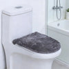 A white toilet features a gray protective seat cover placed on the seat.