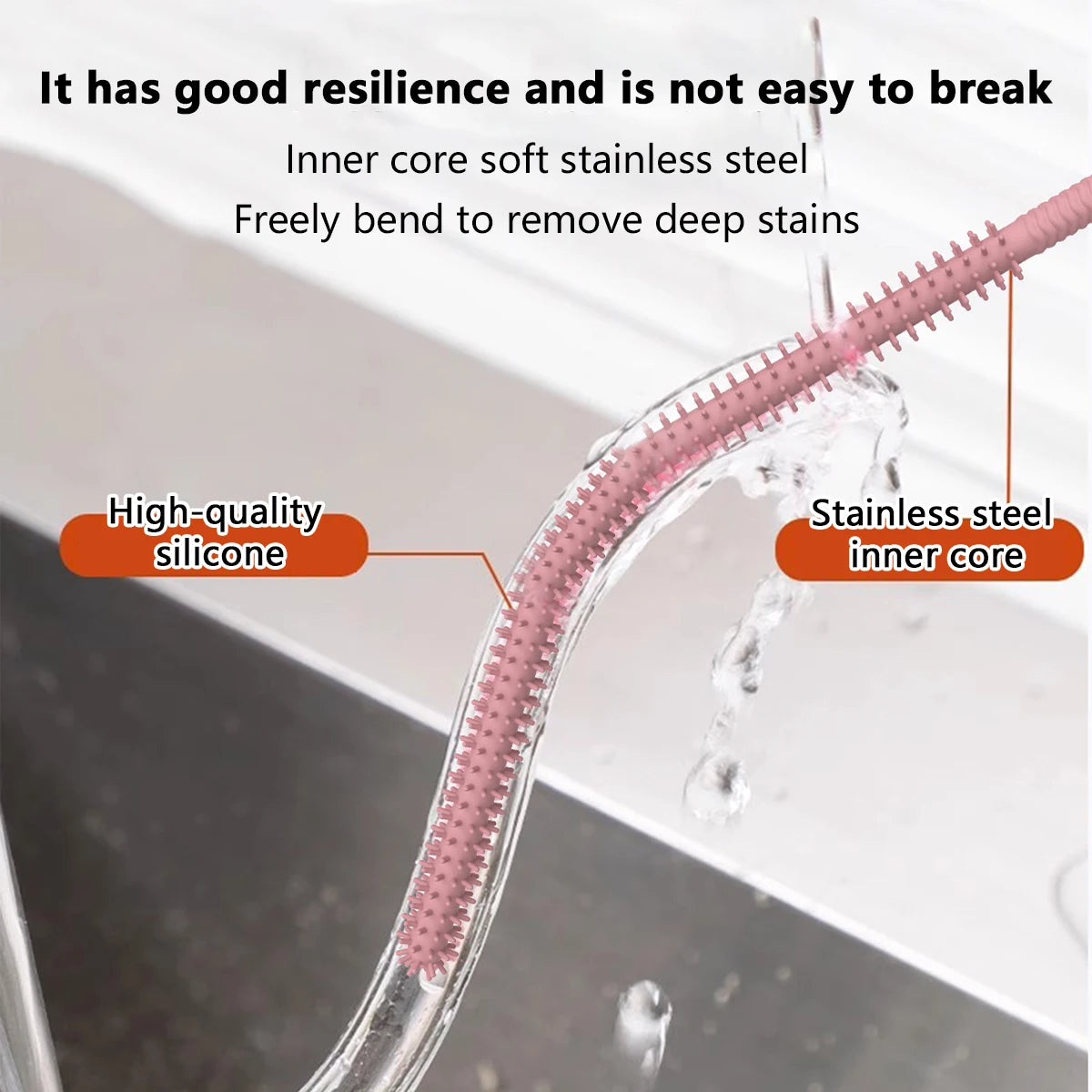 A close-up of a pink silicone straw cleaning brush with a stainless steel inner core being used to remove stains.