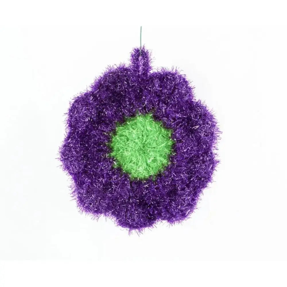 A spherical dish towel made of purple and green fluffy synthetic fibers.