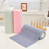 A stack of pink and green reusable microfiber cleaning cloths next to a purple cloth on a white countertop.