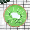 A circular green kiwi fruit design on a brown background placed on a black and white checkered cloth.