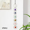 A string of seven silver crystal healing ornaments, each featuring a different colored stone.