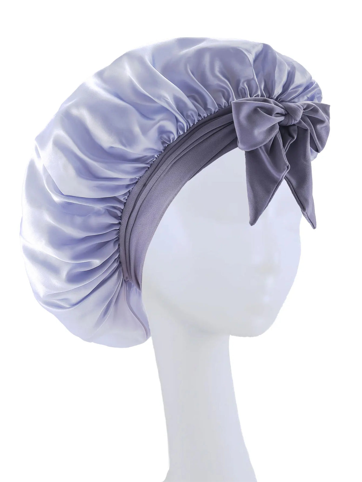 A lavender silky satin sleep bonnet tied with a bow displayed on a white mannequin head.