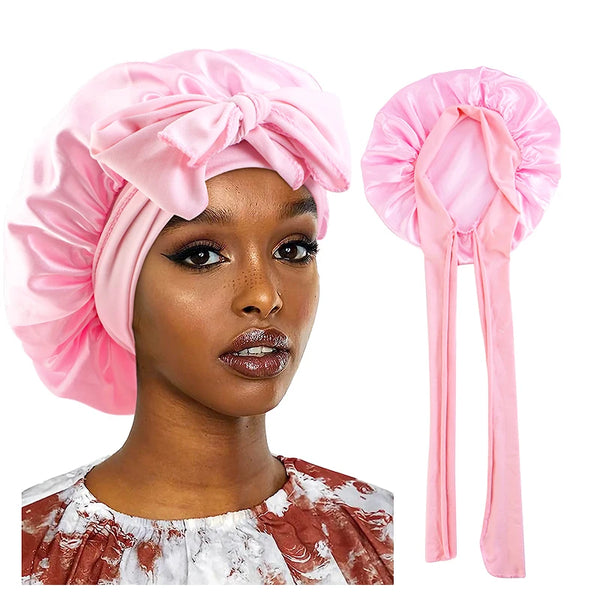 Pink satin sleeping cap and matching hair ties displayed next to a woman wearing the cap