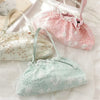 Three light pink and white embroidered fabric bags are displayed on a white surface.
