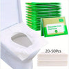 A stack of green disposable toilet seat covers is shown next to a white toilet bowl.
