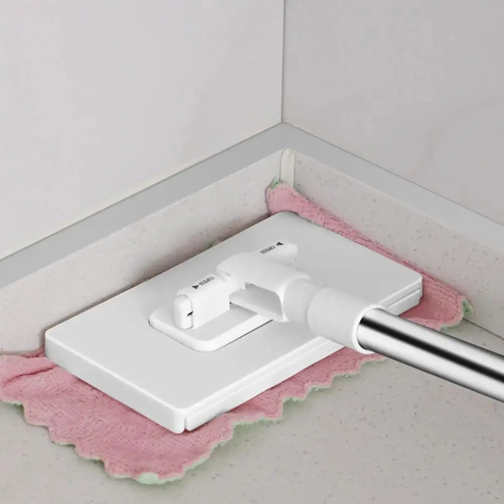 A white hands-free mop with a rotating head and reusable microfiber cloth resting on a pink towel.