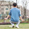 A man is outdoors using a heavy-duty anti-slip clothesline drying rope to dry clothes on grass.