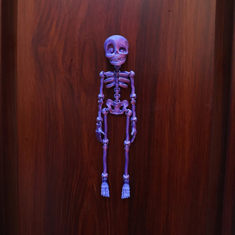 A purple, poseable skull figure made of resin or ceramic, displayed against a dark wooden background.