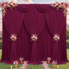 Fondo de tela magenta profunda con cortinas drapeadas y toques florales sobre un césped verde.