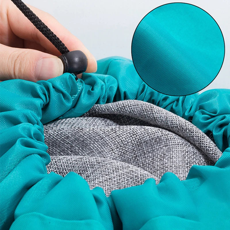 Une main ouvre un sac à linge en tissu bleu sarcelle pour montrer le sac de rangement en filet gris à l'intérieur.