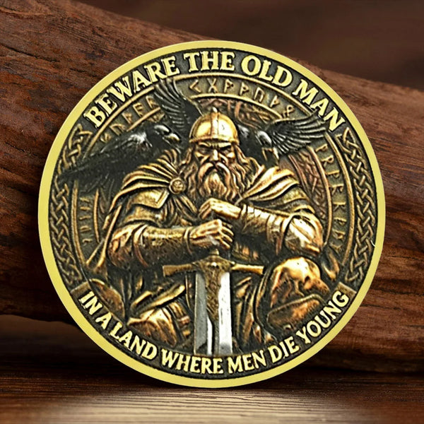 A gold-plated Viking souvenir coin featuring a bearded man holding a sword surrounded by Celtic knotwork and text.