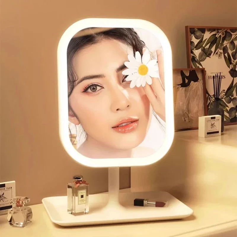 An LED desktop vanity mirror with adjustable lighting displays a close-up of a woman's face.