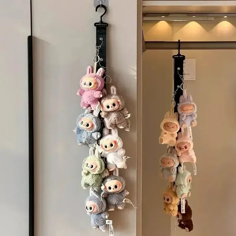 A display rack featuring various Labubu plush toys hanging by charms on a white wall.