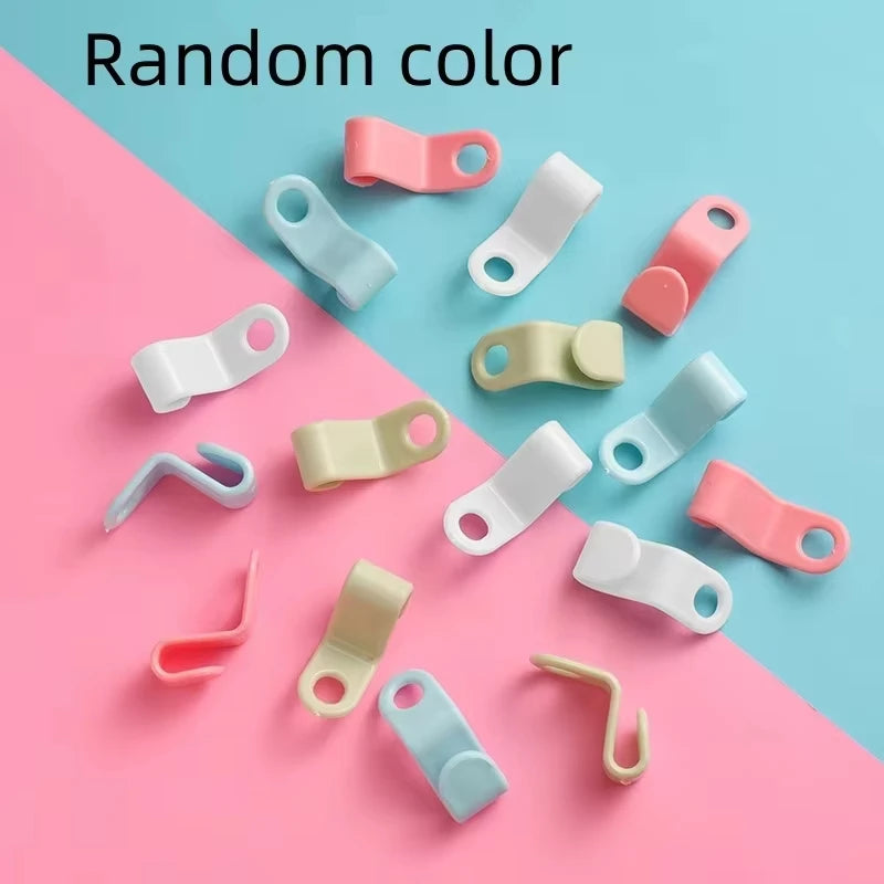 Eine Sammlung verschiedenfarbiger Mini-Kleiderbügel auf pink-blauer Fläche.