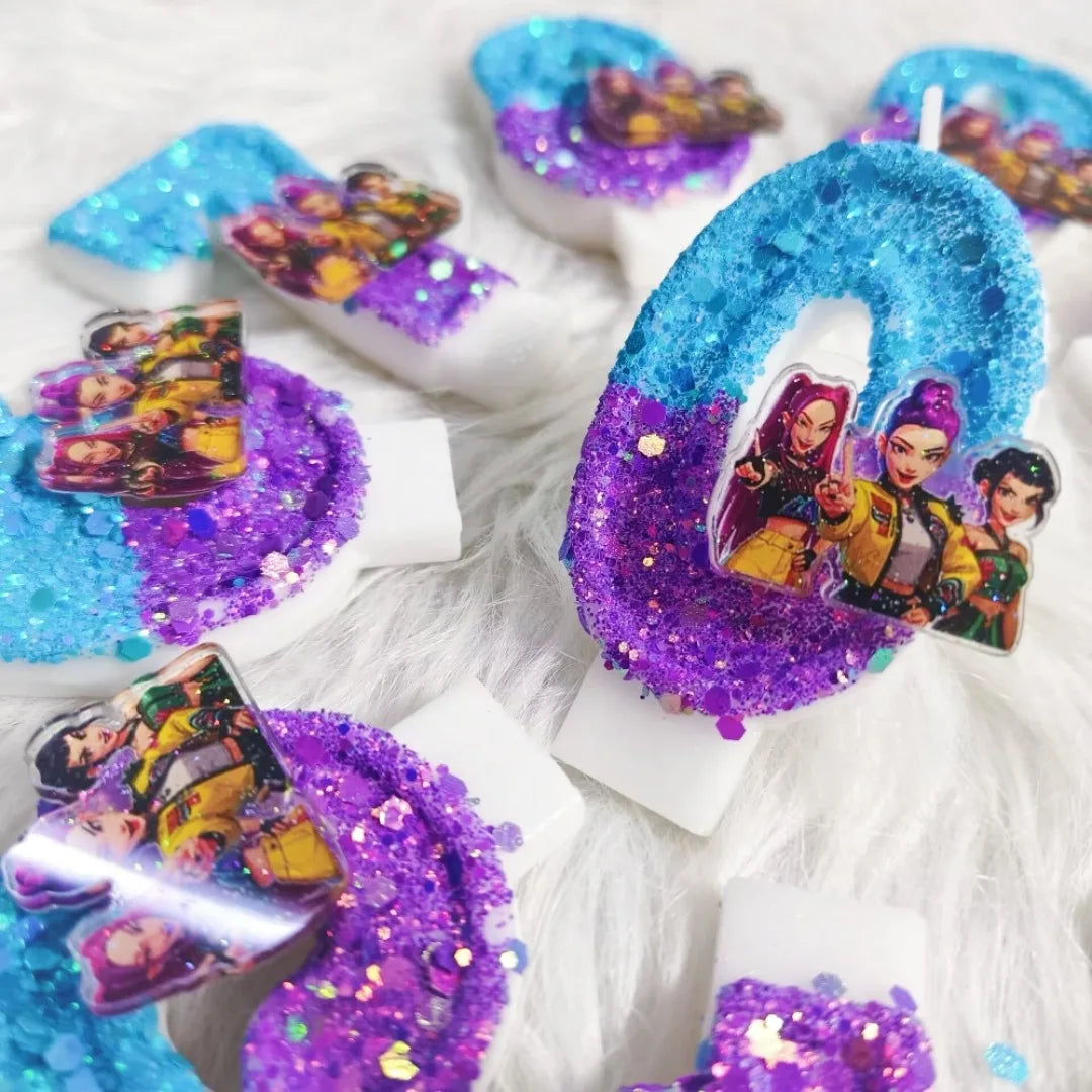 A collection of purple and blue candles decorated with glitter and figures for a birthday celebration.
