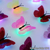 A collection of luminous 3D butterfly wall lights in various colors, including pink, red, and yellow.