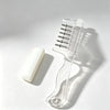 Clear refillable liquid applicator comb with multiple fine teeth resting on a white surface.