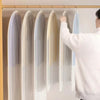 A person is hanging a sheer dust cover over a garment on a wooden rod.
