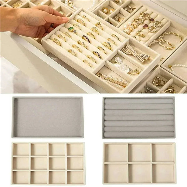 A close-up of a velvet jewelry organizer tray with soft lining showing various rings and necklaces.