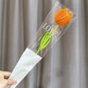 Sleeve in clear plastic with a handmade orange cotton carnation flower and green stem, labeled LOVE.