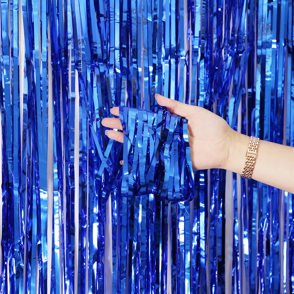 Eine Hand interagiert mit einem vertikalen Vorhang aus glänzendem blauem metallischem Tinselfolienrand.