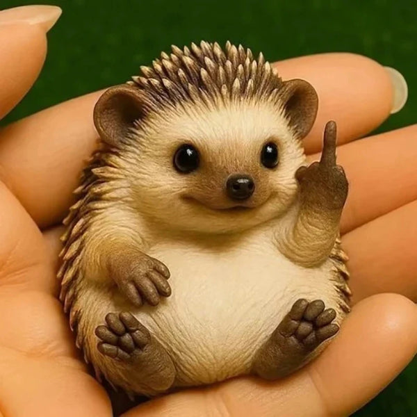 A small, realistic figurine of a mouse or rodent with brown fur and large eyes is held in a person's hand.