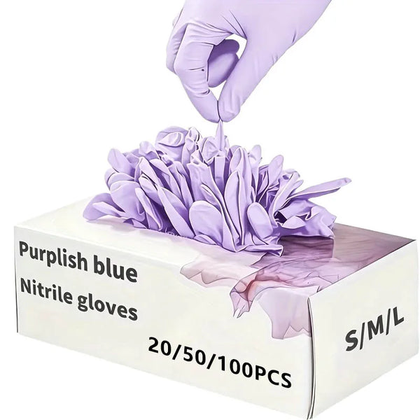 A hand in a purple nitrile glove is placing a cluster of light purple disposable cleaning gloves into a box.