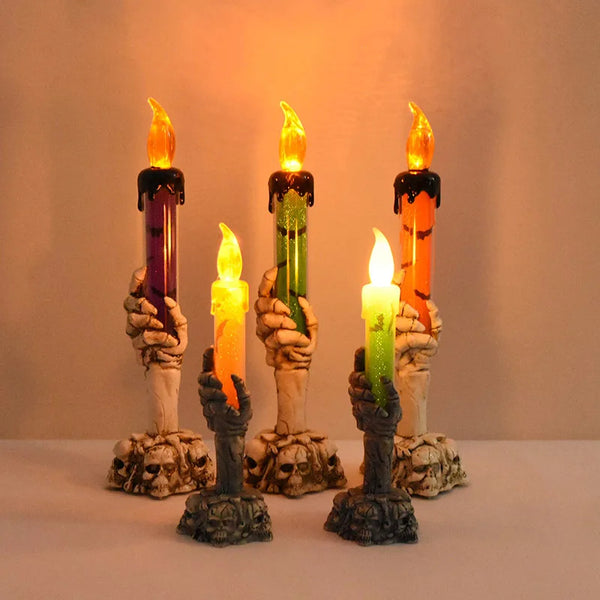A set of skeleton hand shaped LED candles in various colors, including purple, green, and orange.
