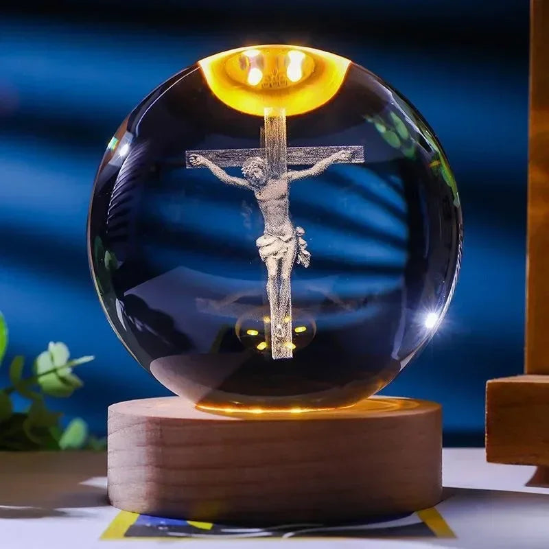 A dark glass crystal ball with a glowing crucifix inside, resting on a wooden base.