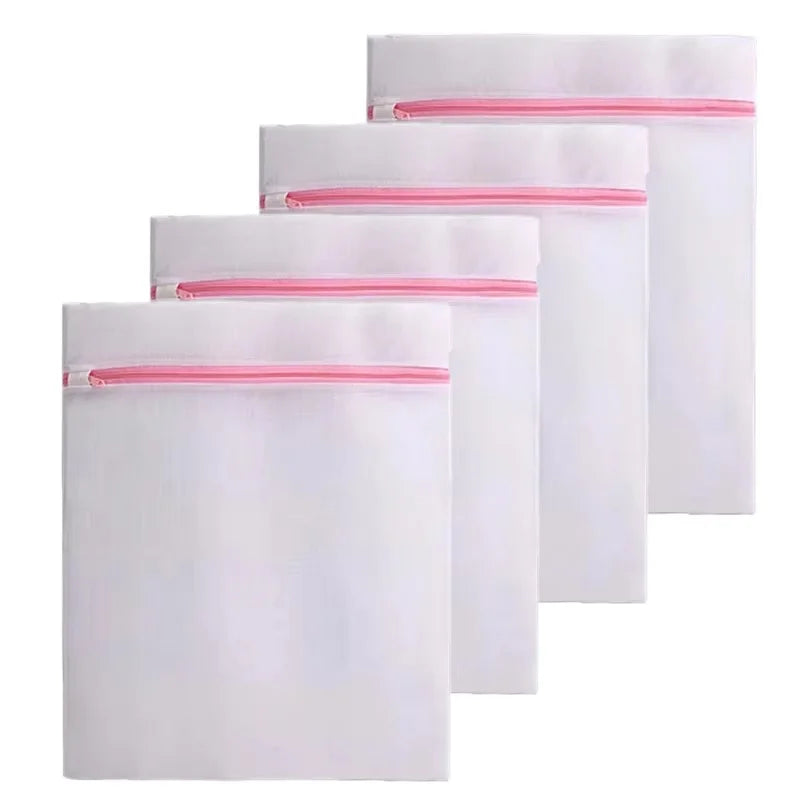 Ein Set aus weißen feinmaschigen Zip-Waschtaschen mit rosa Zierrand.